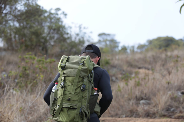 Férfi túrázó hátizsák séta tetején egy hegy táj háttér. - Fotó, kép