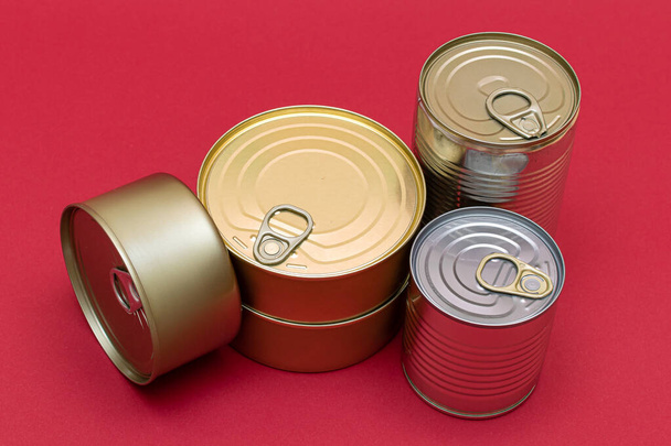 A Group of Stacked Tin Cans with Blank Edges on Red Background. Canned Food. Different Aluminum Cans for Safe and Long Term Storage of Food. Steel Sealed Food Storage Containers - Fotoğraf, Görsel