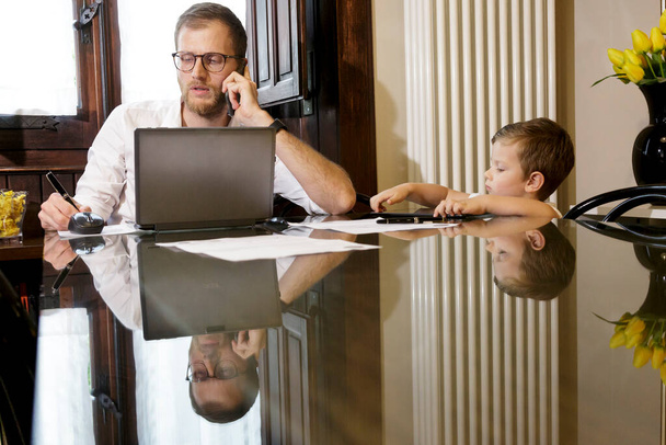 father and little son working at home, family lifestyle concept - Foto, afbeelding