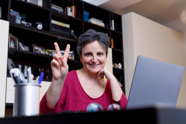 Nainen työskentelee tietokoneen kanssa ja hymyilee - Valokuva, kuva