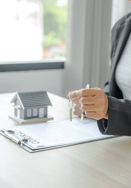 Immobilienmakler hält Schlüssel in der Hand und erklärt Käuferin den Geschäftsvertrag, Miete, Kauf, Hypothek, Darlehen oder Hausversicherung. - Foto, Bild