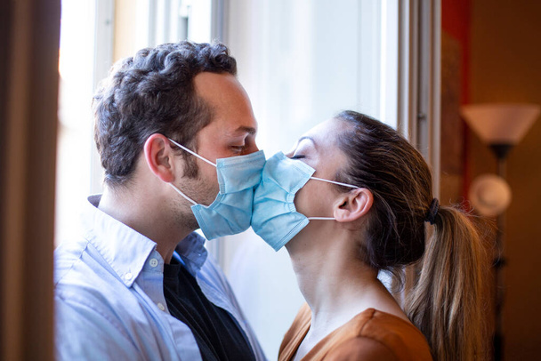 couple in face masks looking at each other in the apartment. - Fotoğraf, Görsel