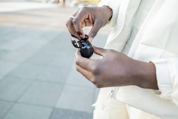 hands of african man puts on wireless headphones - Zdjęcie, obraz