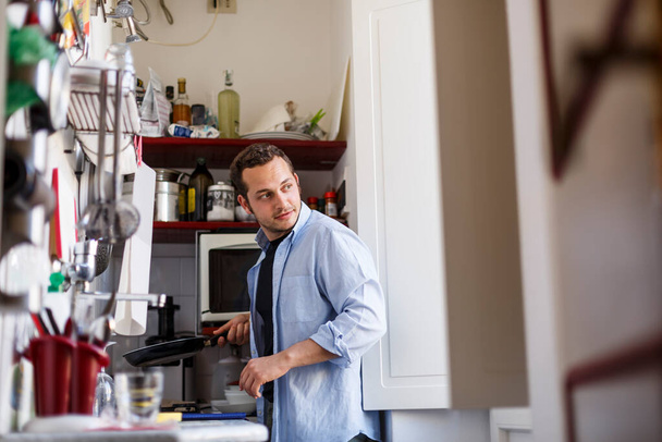 man using a digital tablet in his kitchen - Valokuva, kuva