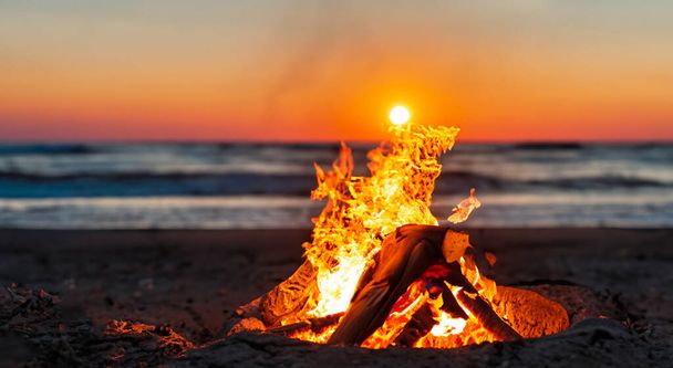 красивий багаття посеред красивого пляжу на приємному заході сонця
 - Фото, зображення