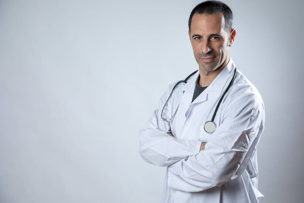 médico de piel oscura y pelo negro con pelaje blanco aislado sobre fondo blanco - Foto, Imagen