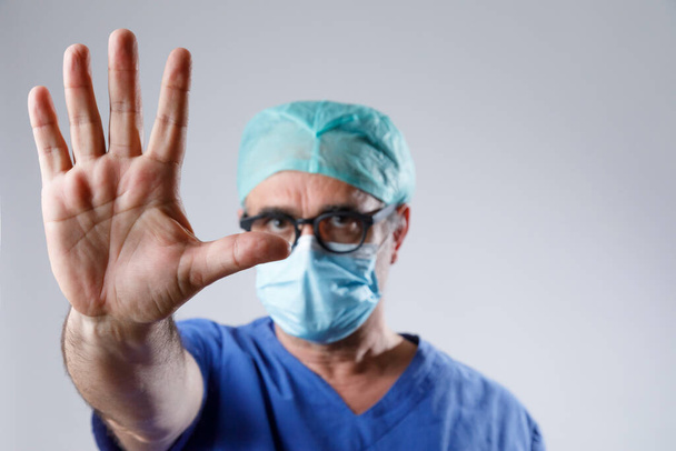 doctor in protective glasses and medical gloves shows stop sign  - Fotoğraf, Görsel