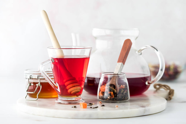 A close up of hibiscus tea with honey against a light back ground. - Photo, Image