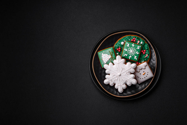 Schöne Weihnachten oder Neujahr bunte hausgemachte Lebkuchen auf einem Keramikteller auf dunklem Betongrund - Foto, Bild