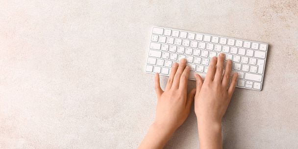 Dłonie kobiety za pomocą nowoczesnej klawiatury komputerowej na tle światła z miejscem na tekst, widok z góry - Zdjęcie, obraz