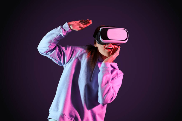 Pretty young woman in VR glasses on black background - Photo, image