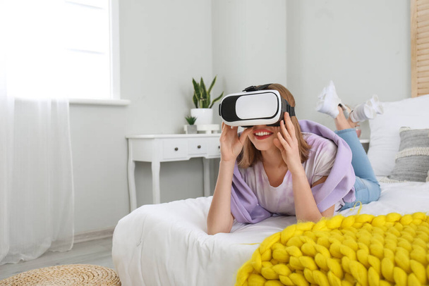 Hübsche junge Frau mit VR-Brille im Schlafzimmer - Foto, Bild