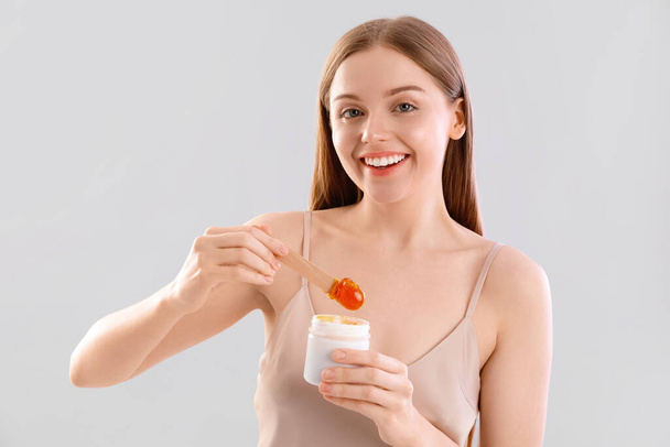 Hezká mladá žena s cukrovinkou pasta na světlém pozadí - Fotografie, Obrázek