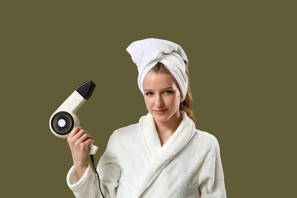 Pretty young woman with hair dryer on color background - Photo, Image