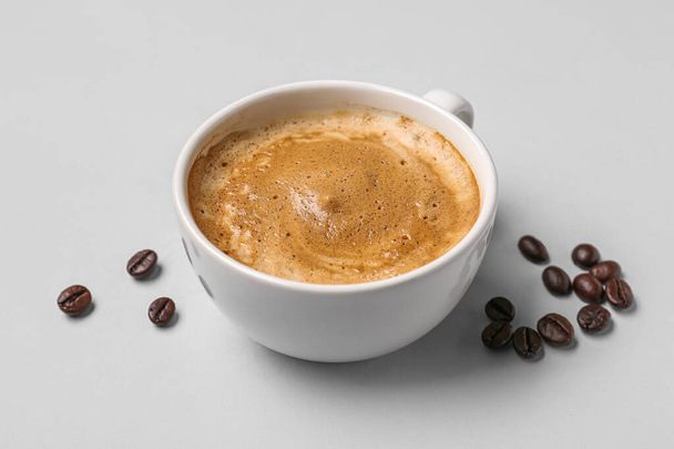 Kuppi kuumaa espressoa ja kahvipapuja harmaalla pohjalla - Valokuva, kuva