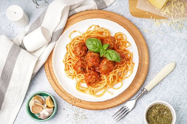 Plaat van gekookte pasta met tomatensaus en vleesballen op witte tafel - Foto, afbeelding