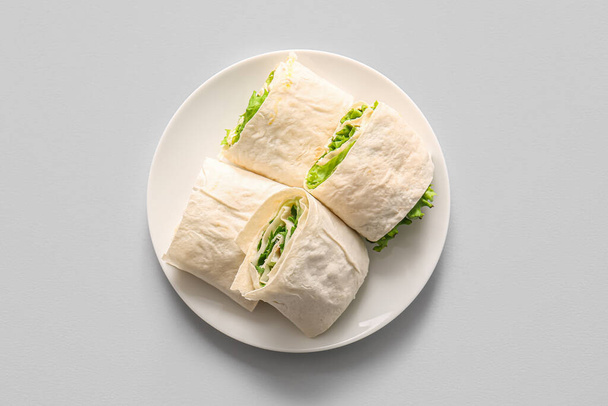 Plate of tasty lavash rolls with greens on grey background - Zdjęcie, obraz