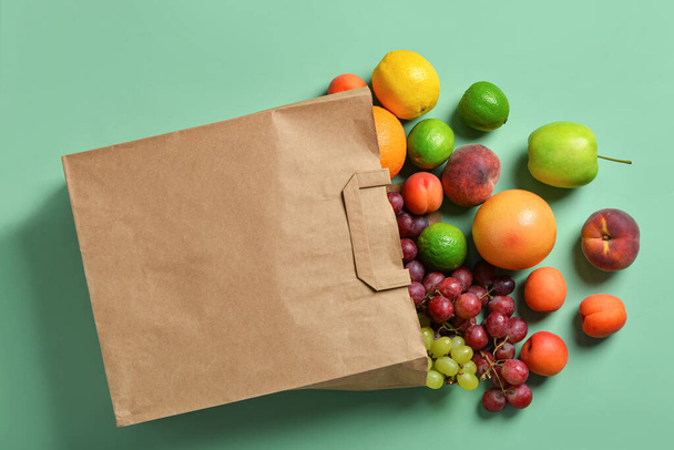 Paper bag with fresh fruits on turquoise background - Fotoğraf, Görsel