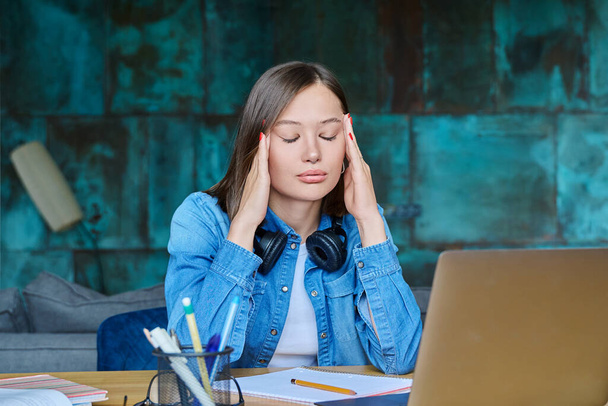 Unhappy sad female university student at home at her desk. Face of 20s young woman, stressed difficult situation, problems in studies - Foto, Bild