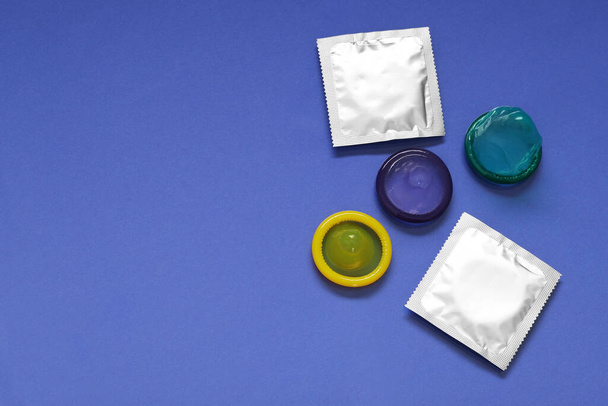 Unpacked condoms and packages on blue background, flat lay with space for text. Safe sex - Zdjęcie, obraz