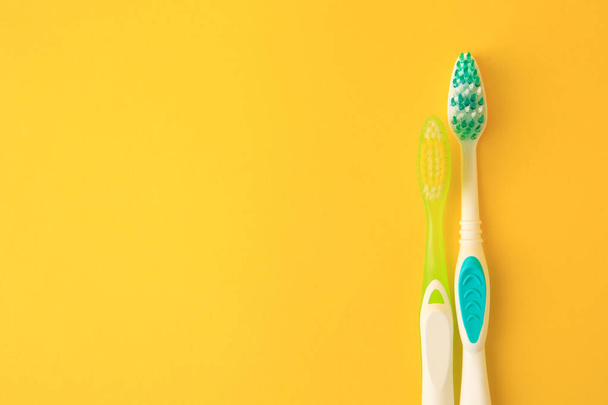 Toothbrushes on yellow background, flat lay. Space for text - Photo, Image