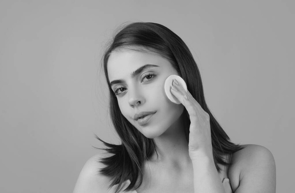 Closeup face of beautiful young woman with cotton pads, sponge, cotton ball. Skin care and beauty concept. Girl removes makeup with cotton ball from face. Skin care concept. Woman using cotton pad - Foto, Bild