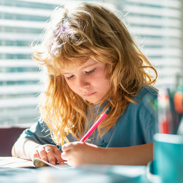Child writing homework in school class. Preteen schoolboy doing her homework at home. Child study. Education and learning for kids. Cute little boy doing homework in classroom - Foto, Imagen