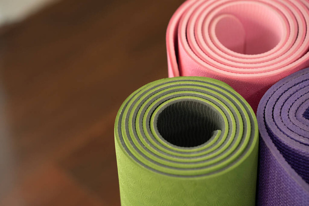 close up of colorful yoga mat on the table, sport and healthy concept - Foto, afbeelding