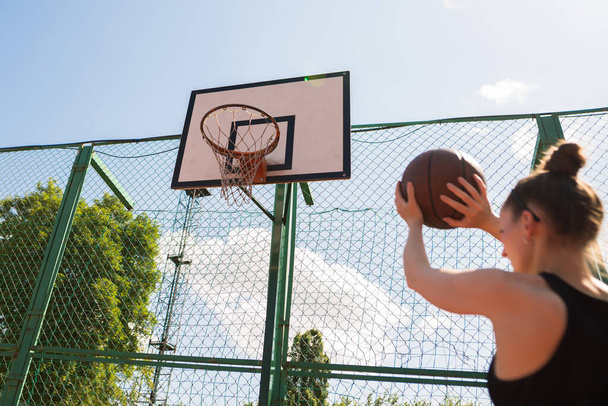 Atletische vrouwelijke basketbalspeler gooien van een bal op het net. - Foto, afbeelding