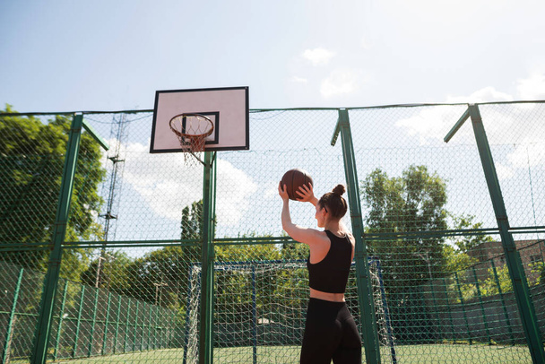 Спортсменка-баскетболістка кидає м'яч до мережі
. - Фото, зображення