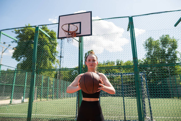 Athletic female basketball player throwing a ball up to the net. - Foto, imagen