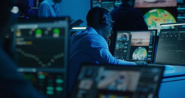Afroameričtí zaměstnanci monitorují vesmírné mise na počítači s více monitory v řídícím středisku mise. Týmové sledování úspěšného vzletu kosmické lodi na velké digitální obrazovce. Průzkum vesmíru. - Fotografie, Obrázek