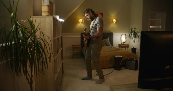 Homem toca guitarra no quarto. - Foto, Imagem