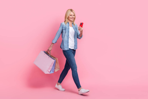 Full length body photo of senior woman enjoy shopping stores online order free delivery over 50 dollars isolated on pink color background. - Foto, imagen