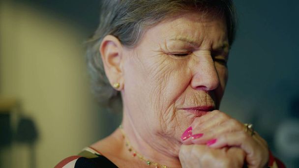 Seniorin tief im Gebet, Großaufnahme eines älteren treuen Gesichts. Besinnliches Thema der Hoffnung in betender Besinnung - Foto, Bild