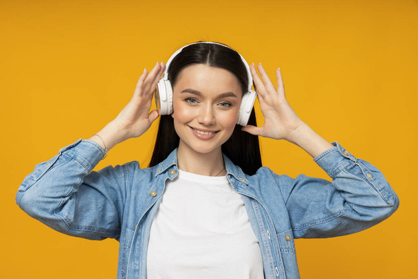 A young woman in a denim shirt and headphones - Photo, Image
