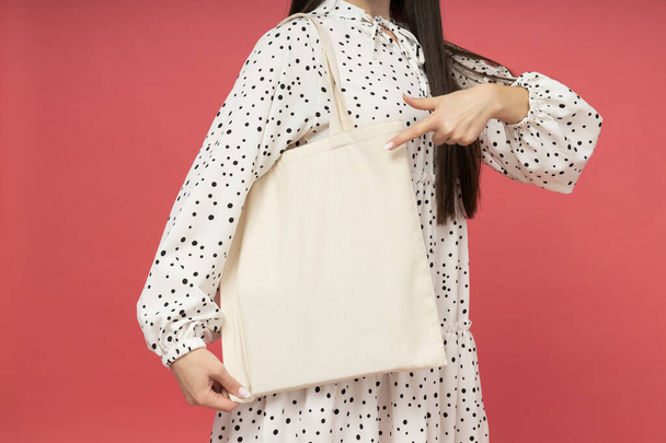Mesaj atmak için yeri olan alışveriş çantalı genç bir kadın. - Fotoğraf, Görsel