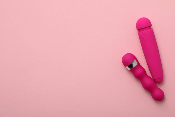 Two pink vibrators on a pink background, place for text - Foto, immagini