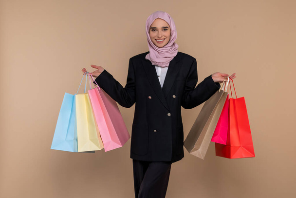 After shopping. Young muslim elegant woman with shopping bags looking contented - Fotó, kép