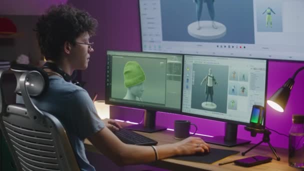 Jonge 3D-ontwerper creëert spel karakter of kleding, werkt aan project thuis. Tiener traint 3D-modellering op computer en groot digitaal scherm met professionele software-interface en tools voor het ontwerp. - Video