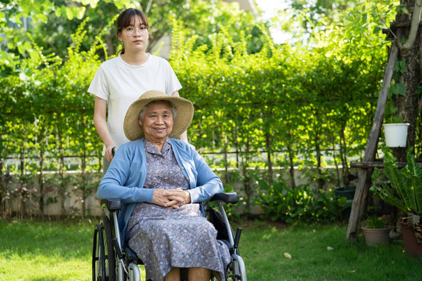 φροντιστής βοήθεια και φροντίδα ασιατική ηλικιωμένη γυναίκα ασθενής κάθεται σε αναπηρική καρέκλα στο θάλαμο νοσηλευτικό νοσοκομείο, υγιή ισχυρή ιατρική έννοια. - Φωτογραφία, εικόνα