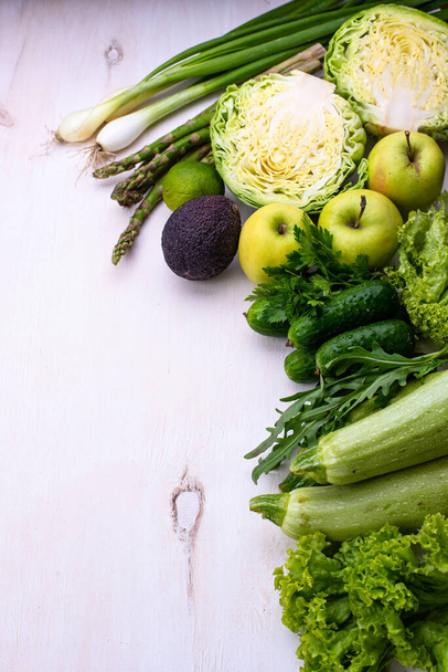 Különböző zöldségek és gyümölcsök. Spárga, uborka, káposzta, cukkini, alma, avokádó és hagyma - Fotó, kép