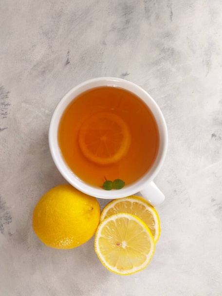 A cup of hot lemon tea. Isolated background in white - Valokuva, kuva
