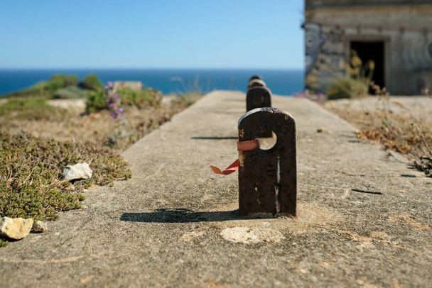 Rusty metal mount near an abandoned coastal building in Portugal - Foto, Bild