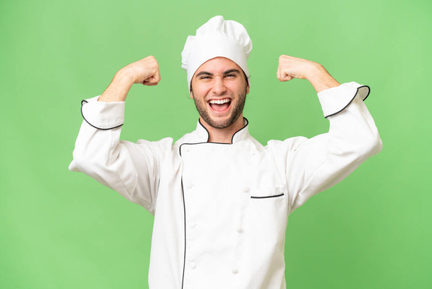 jovem bonito chef homem sobre isolado fundo fazendo forte gesto - Foto, Imagem