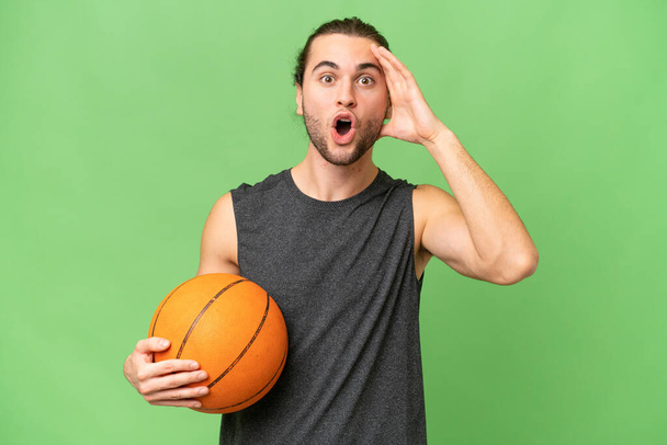 młody koszykarz człowiek na odosobnionym tle z ekspresją zaskoczenia - Zdjęcie, obraz