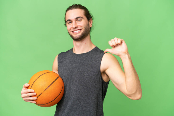 Giovane giocatore di basket uomo su sfondo isolato orgoglioso e soddisfatto di sé - Foto, immagini