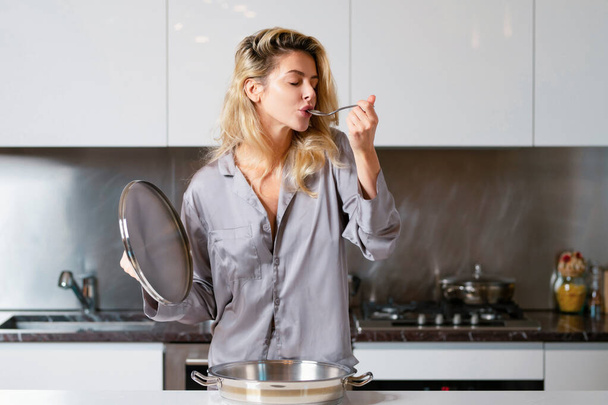 Girl with cooking pot, doing housework. Housekeeping concept. Young woman cooking breakfast. Sexy slim woman at home in morning. Taste and delicious - Фото, зображення