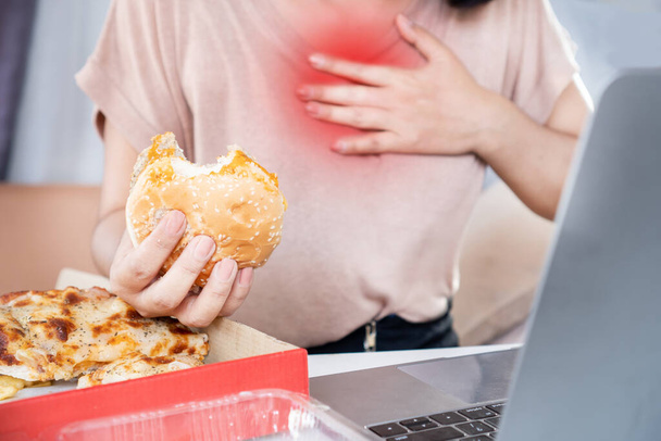 donna che soffre di reflusso acido, bruciore di stomaco dopo aver mangiato cibo spazzatura, pizza e hamburger - Foto, immagini