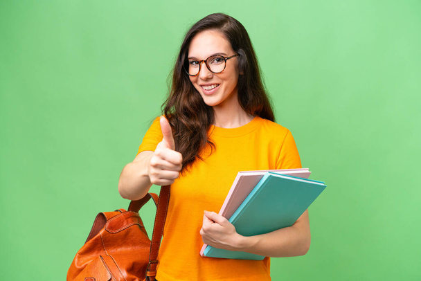 Young student caucasian woman over isolated background with thumbs up because something good has happened - Fotoğraf, Görsel